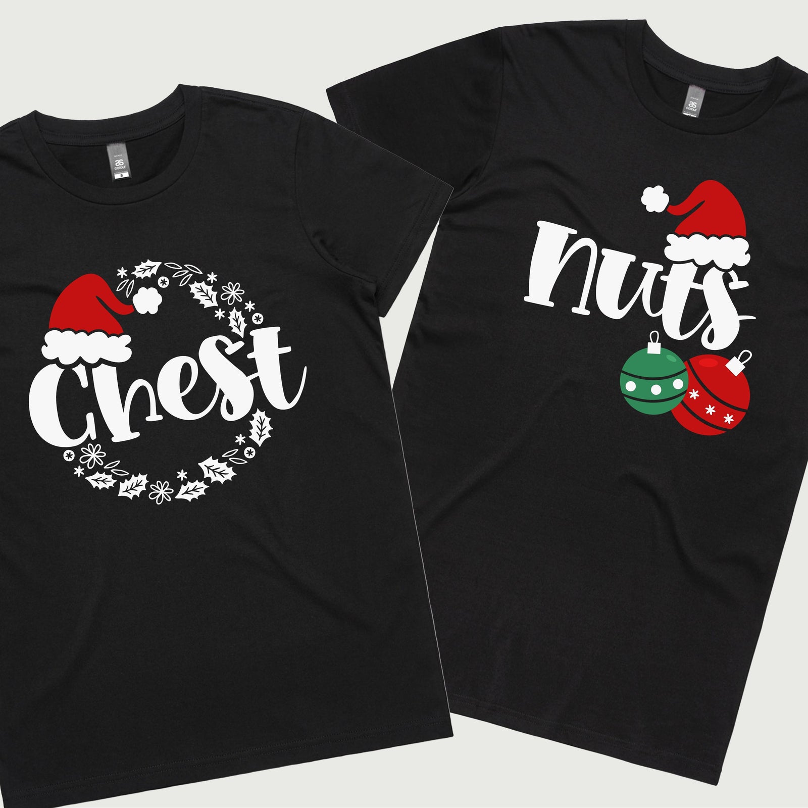 Two black T-shirts, one with a white Christmas tree and green ornaments, and the other with a black Christmas tree and red ornaments. Both shirts have 'CHEST' and 'NUTS' text in white.