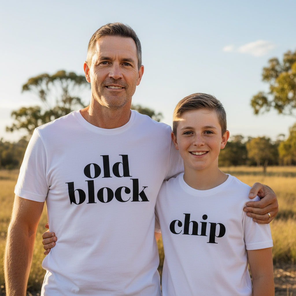 Father and son in white t-shirts. Father's reads 'old block' and child's reads 'chip'