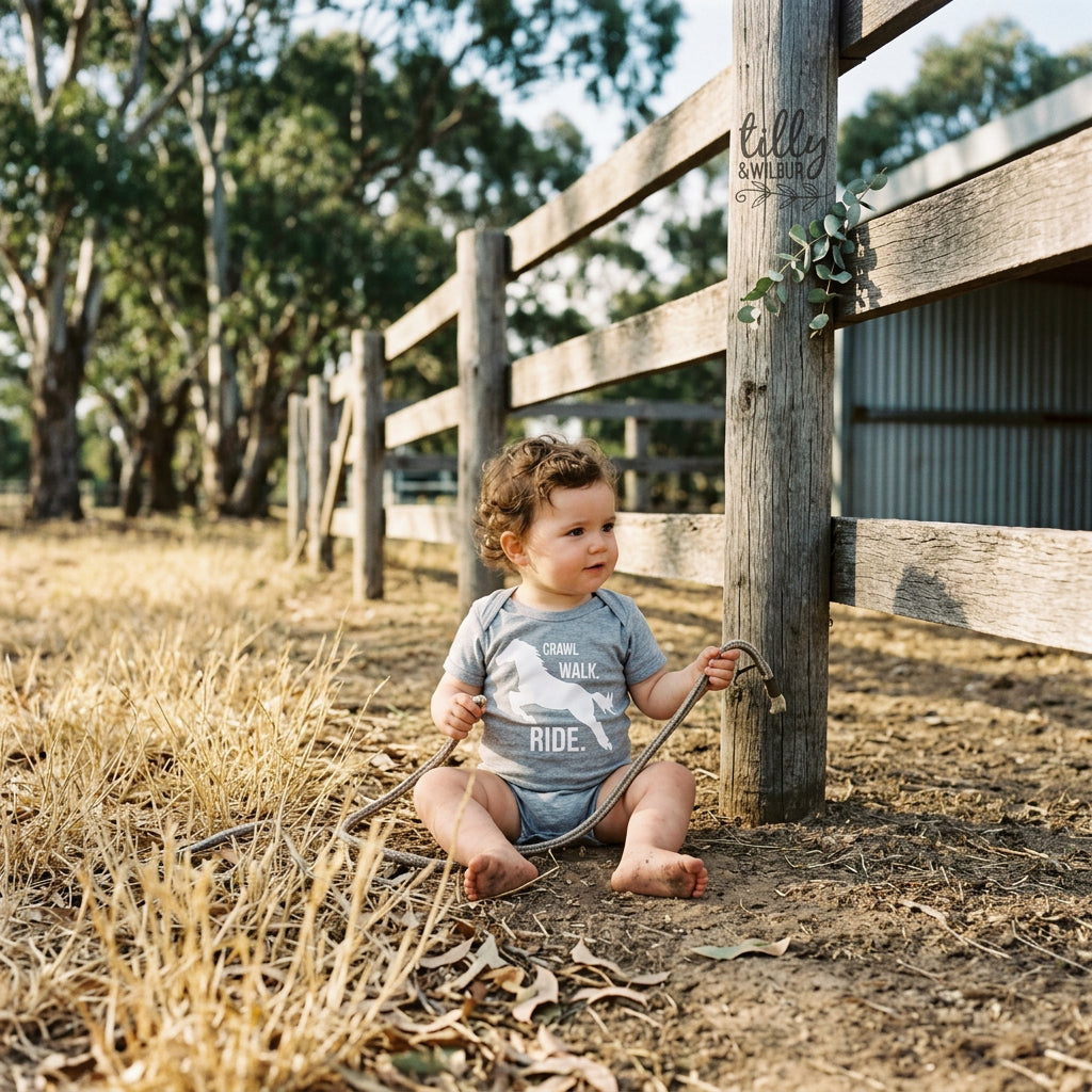 Baby bodysuit with a galloping horse silhouette and the words Crawl Walk Ride.