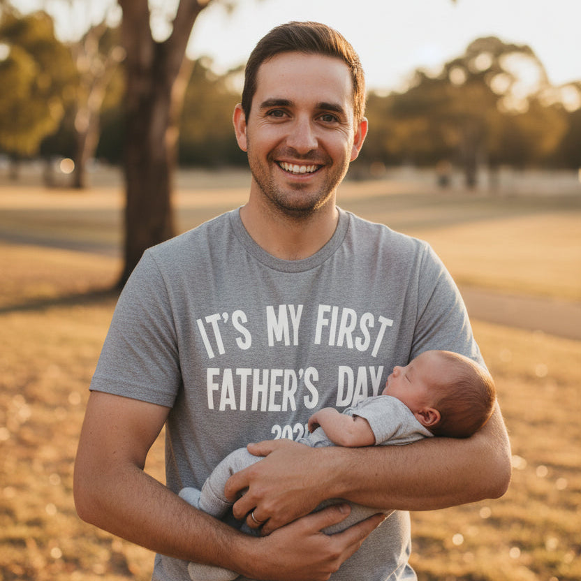 Grey men's tee that reads It's My First Father's Day with the year