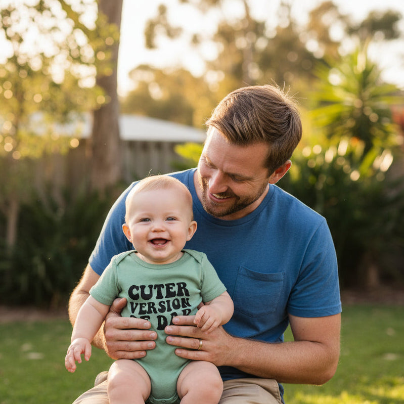 Green baby onesie with 'CUTER VERSION OF DAD' text on a white background