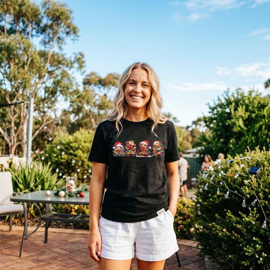 Black t-shirt with four wombats in Santa hats tangled in colourful Christmas fairy lights.