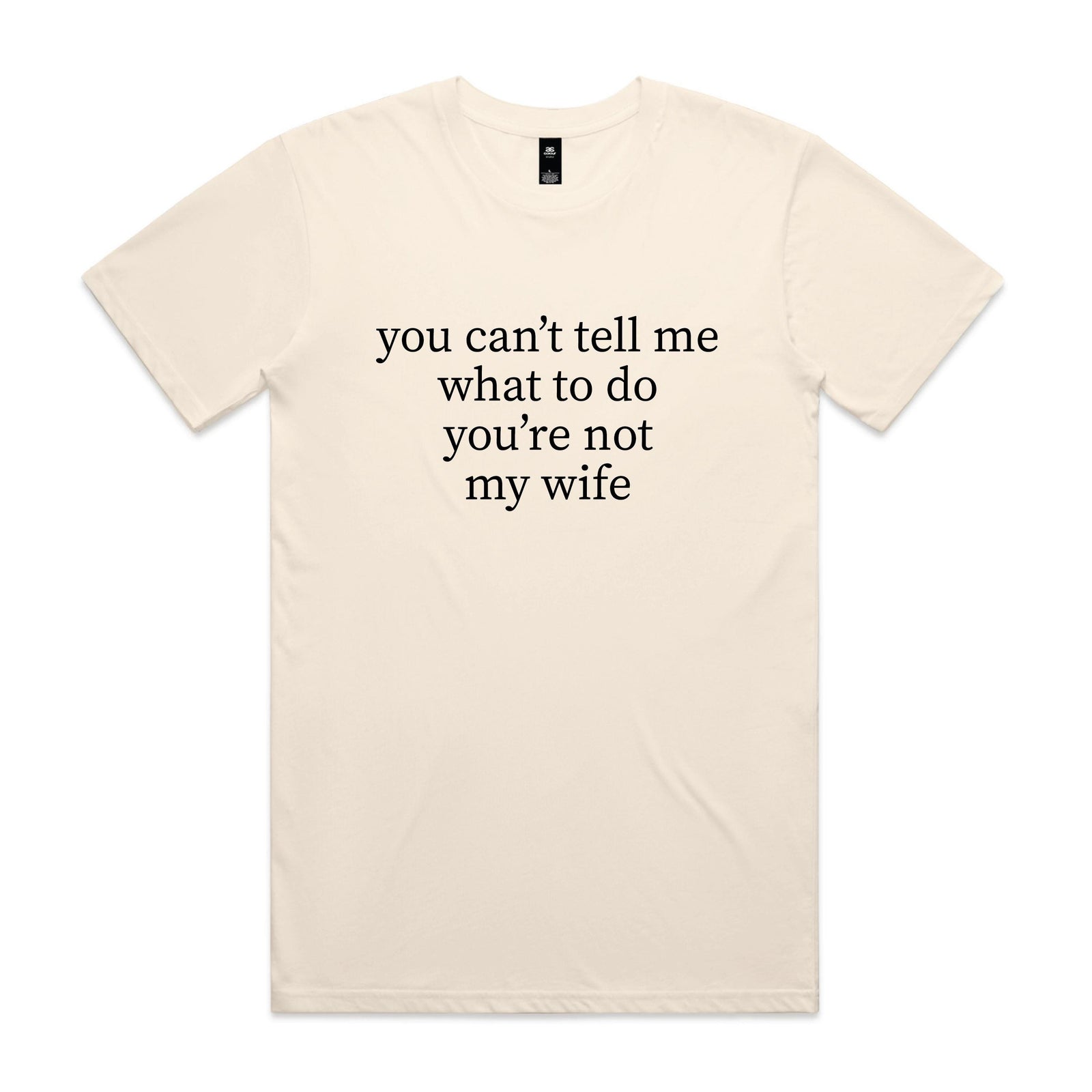 Natural cream t-shirt with black serif text reading you can't tell me what to do you're not my wife, displayed flat against a white background.
