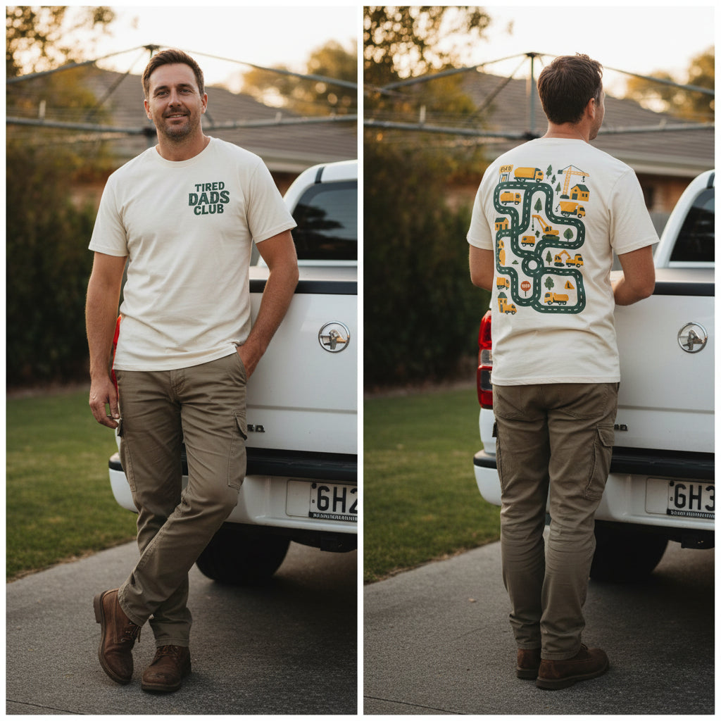 An off-white short-sleeve t-shirt shown from both the front and back. The front features the text 'TIRED DADS CLUB' printed in dark green on the left chest.