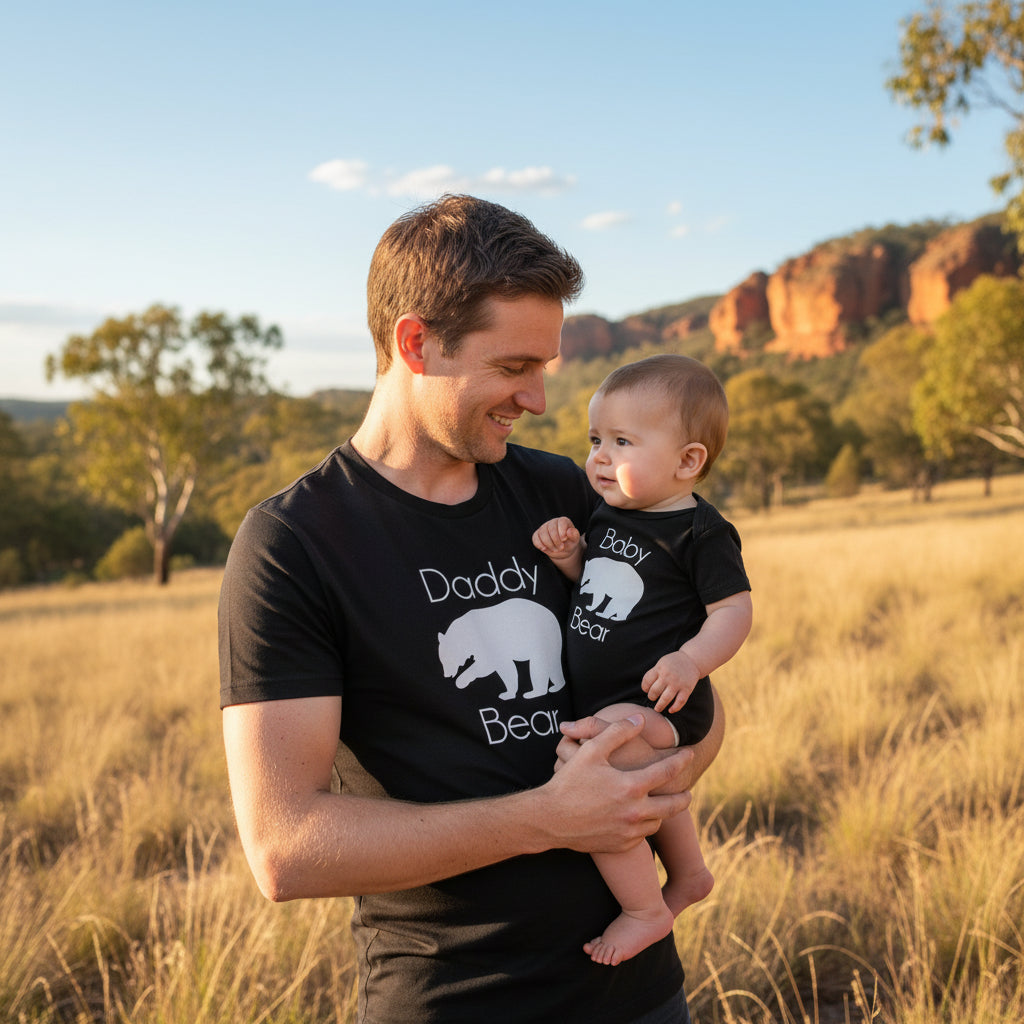 Black adult t-shirt reading Daddy Bear and black baby bodysuit reading Baby Bear, both with a white bear silhouette.