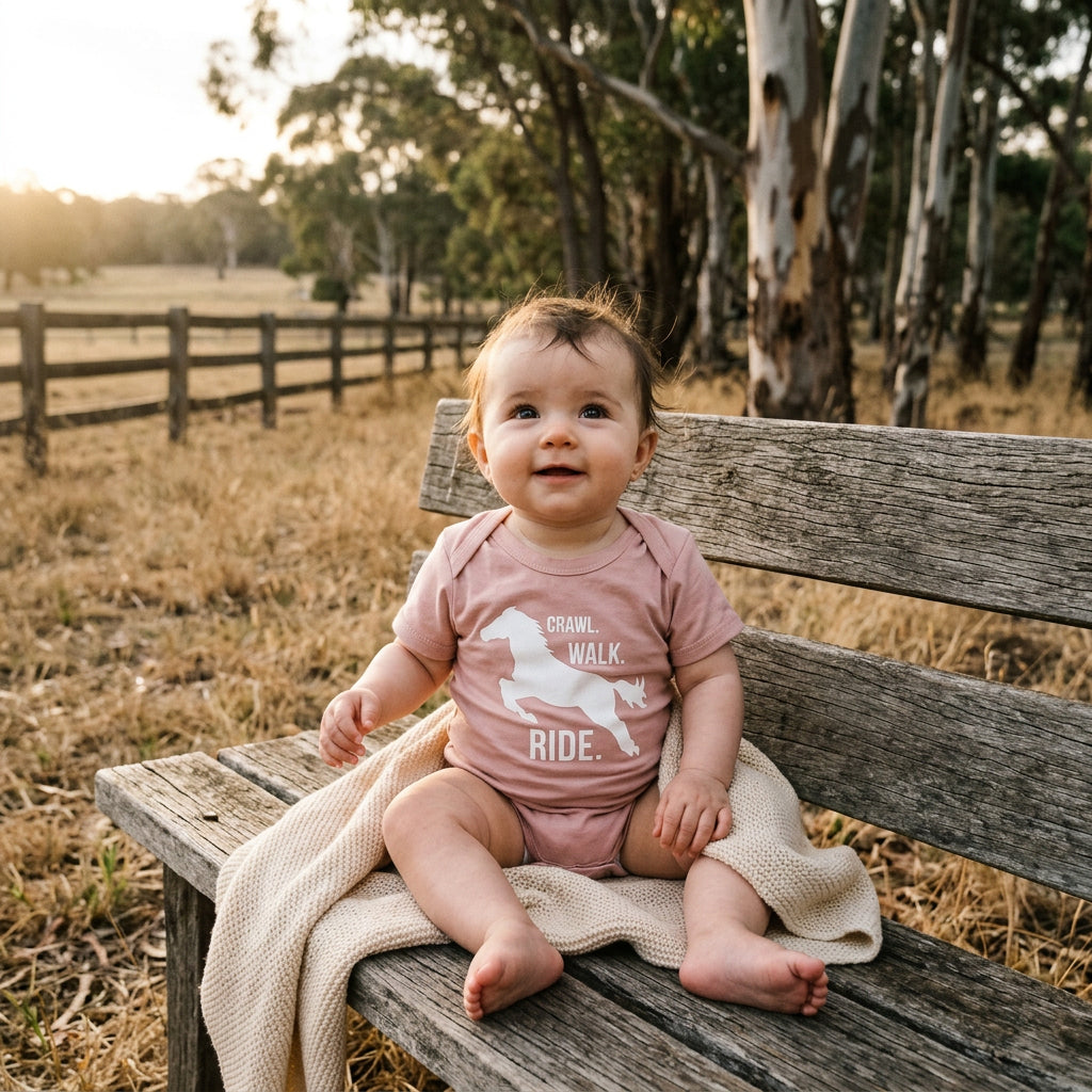 Baby bodysuit with a galloping horse silhouette and the words Crawl Walk Ride.