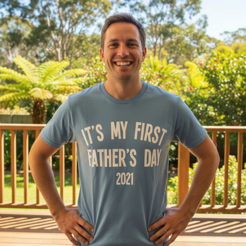 Blue men's tee that reads It's My First Father's Day with the year