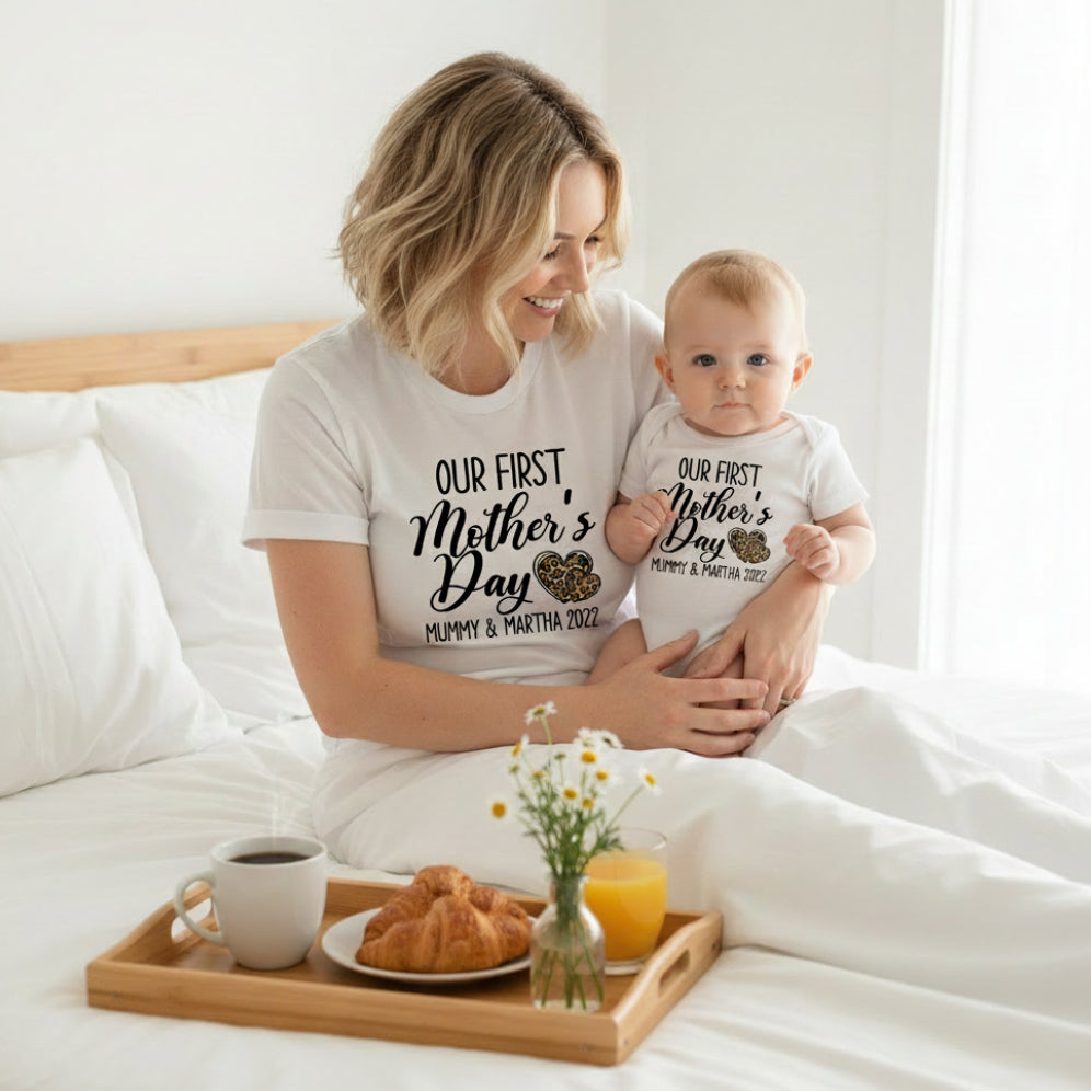 White t-shirt and baby bodysuit reading Our First Mother's Day with leopard print hearts and personalised names and year.