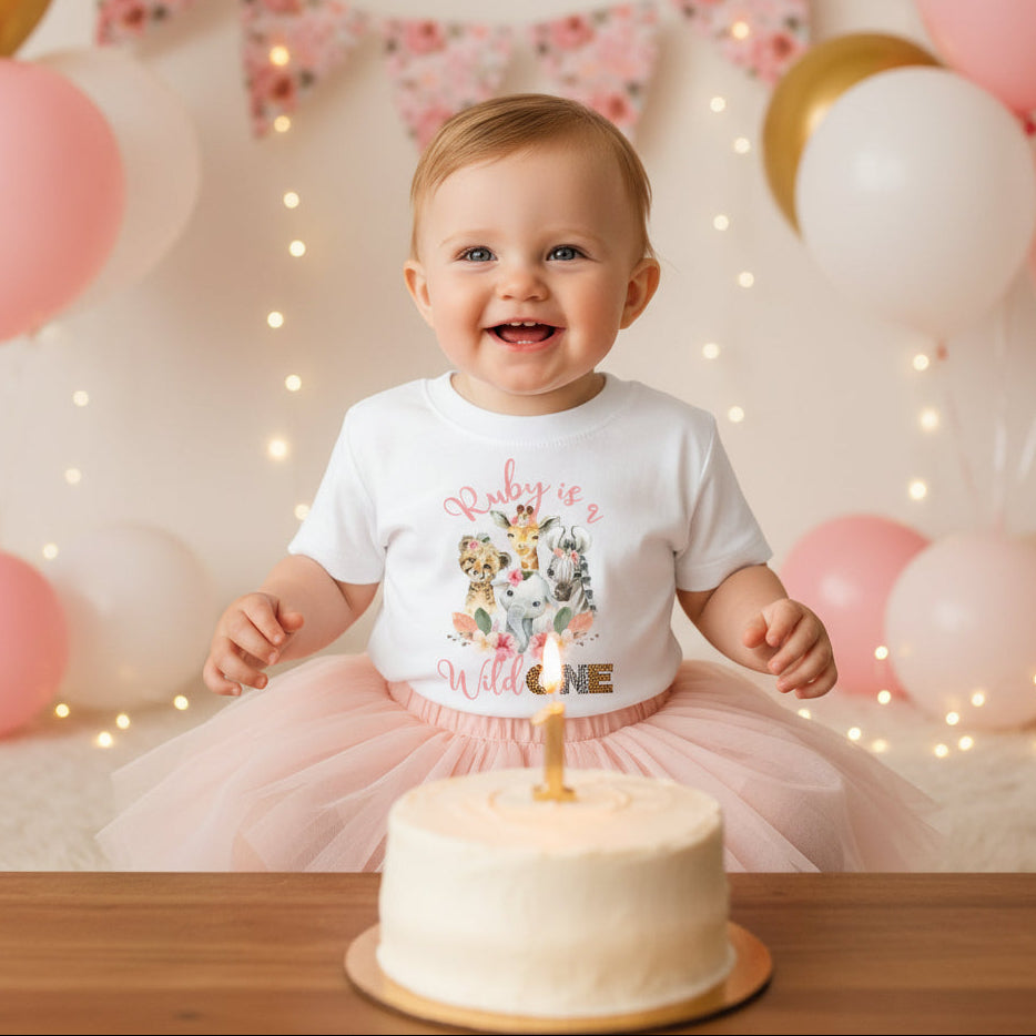 White kids t-shirt with watercolour safari animals, florals and a personalised name above Wild One.