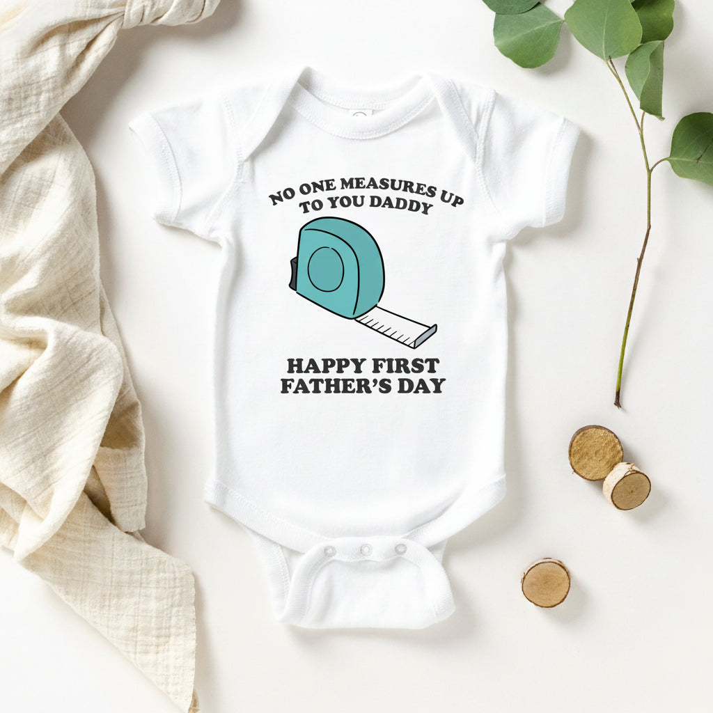 White baby bodysuit with a tape measure design and text reading No One Measures Up To You Daddy, Happy First Father's Day.
