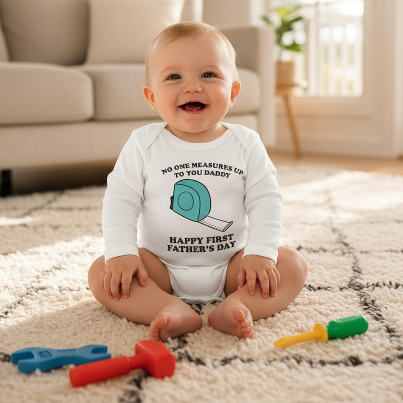 White baby bodysuit with a tape measure design and text reading No One Measures Up To You Daddy, Happy First Father's Day.