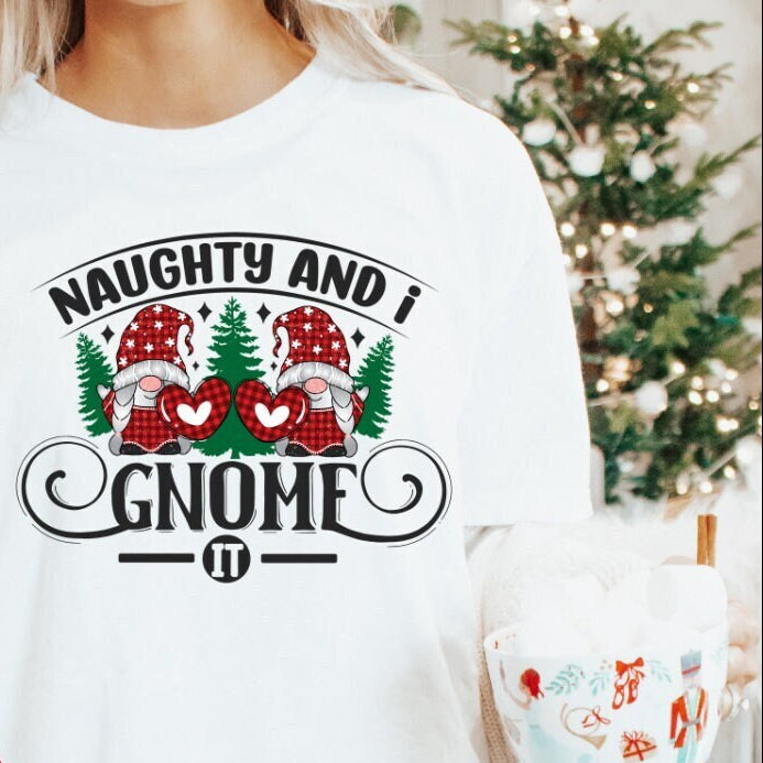 A woman wearing a white long-sleeve t-shirt with the text 'Naughty and I Gnome It!' and Christmas-themed decorations such as gnomes, trees, and hearts.
