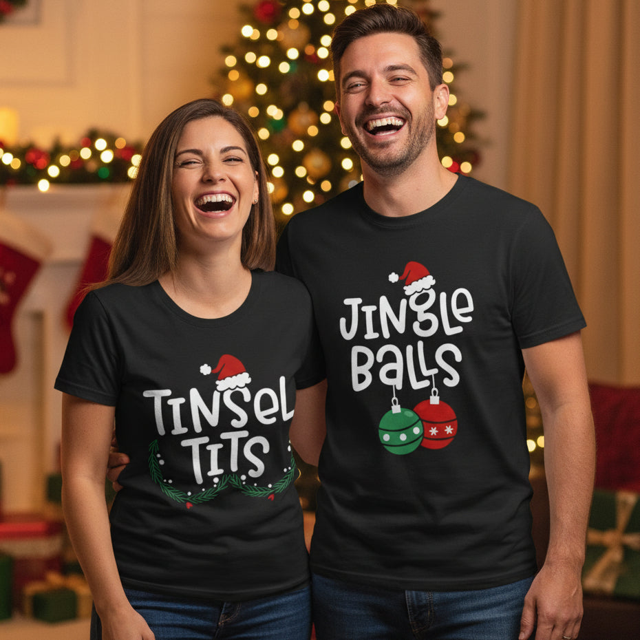 Two black t-shirts, one with the text 'TINSEL TITS' and Christmas-themed decorations, and the other with 'JINGLE BALLS' and a Christmas tree graphic. Both shirts have a festive, Christmas-themed design.
