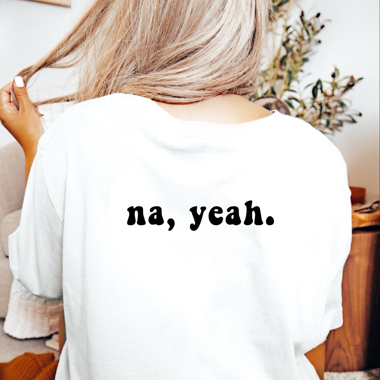 White t-shirt with 'yeah, na.' text on front and 'na, yeah.' text on back worn by a person.