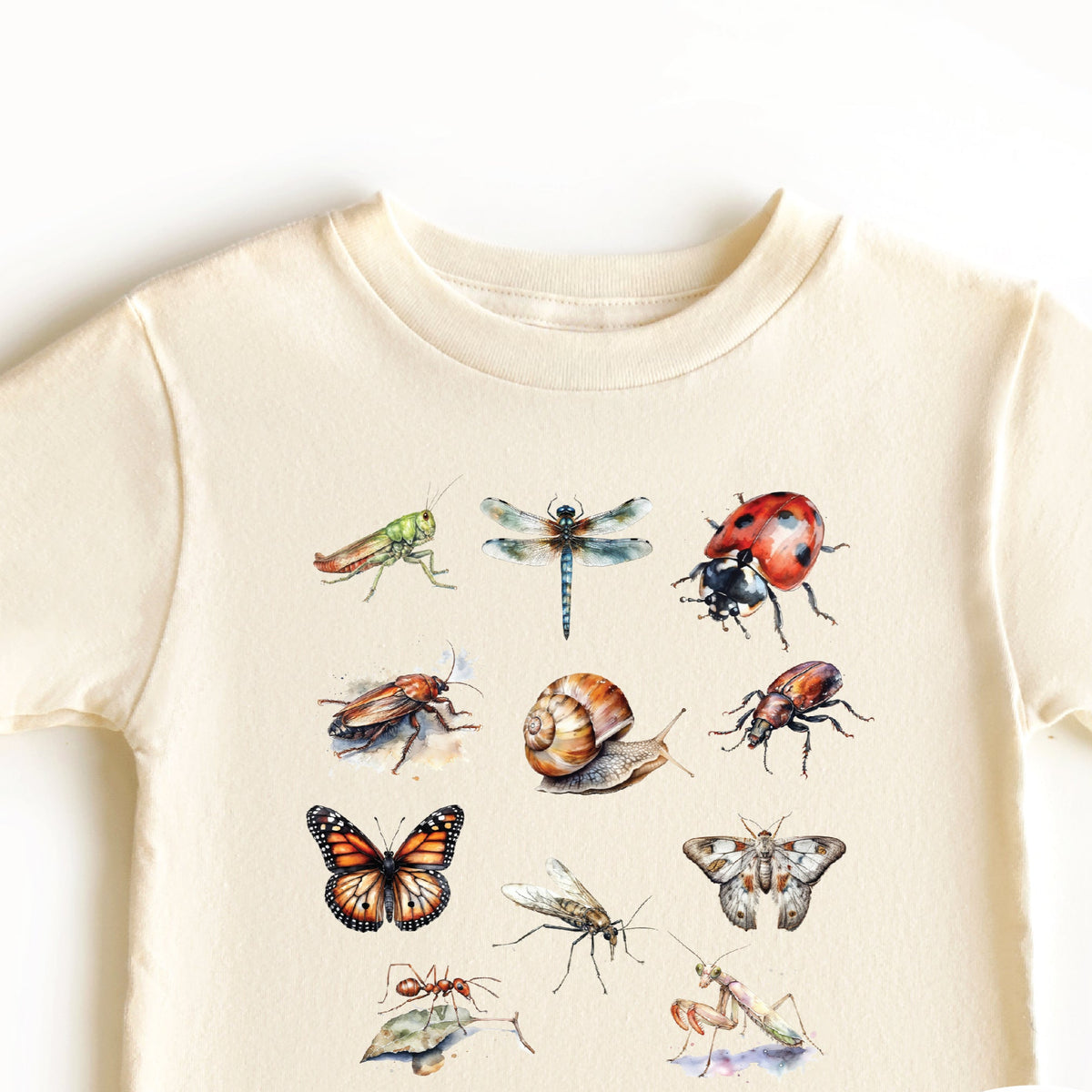 A beige t-shirt with a collection of colorful illustrated bugs and the text &#39;LOTS OF SELLES &amp; COLOURS&#39;.