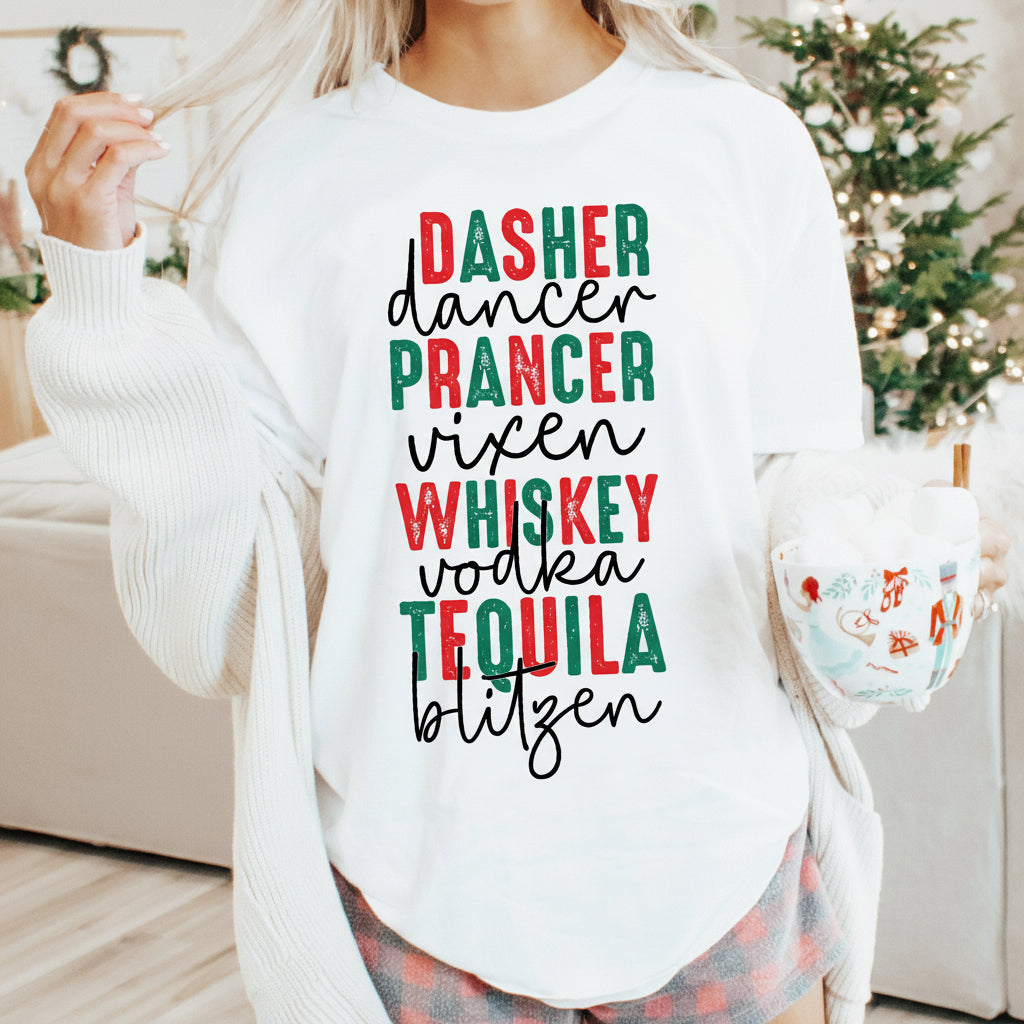 A person wearing a white sweatshirt with text that reads 'Dasher, Dancer, Prancer, Vixen, Whiskey, Tequila, Blitzen' on the front, holding a mug, with a Christmas tree and gifts in the background.