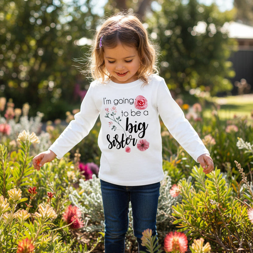 Child wearing floral big sister announcement shirt outdoors