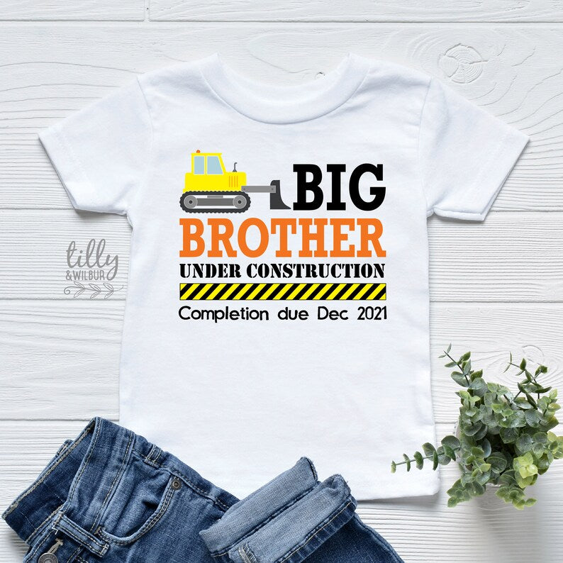 White kids t-shirt with a bulldozer reading Big Brother Under Construction and a personalised completion due date.