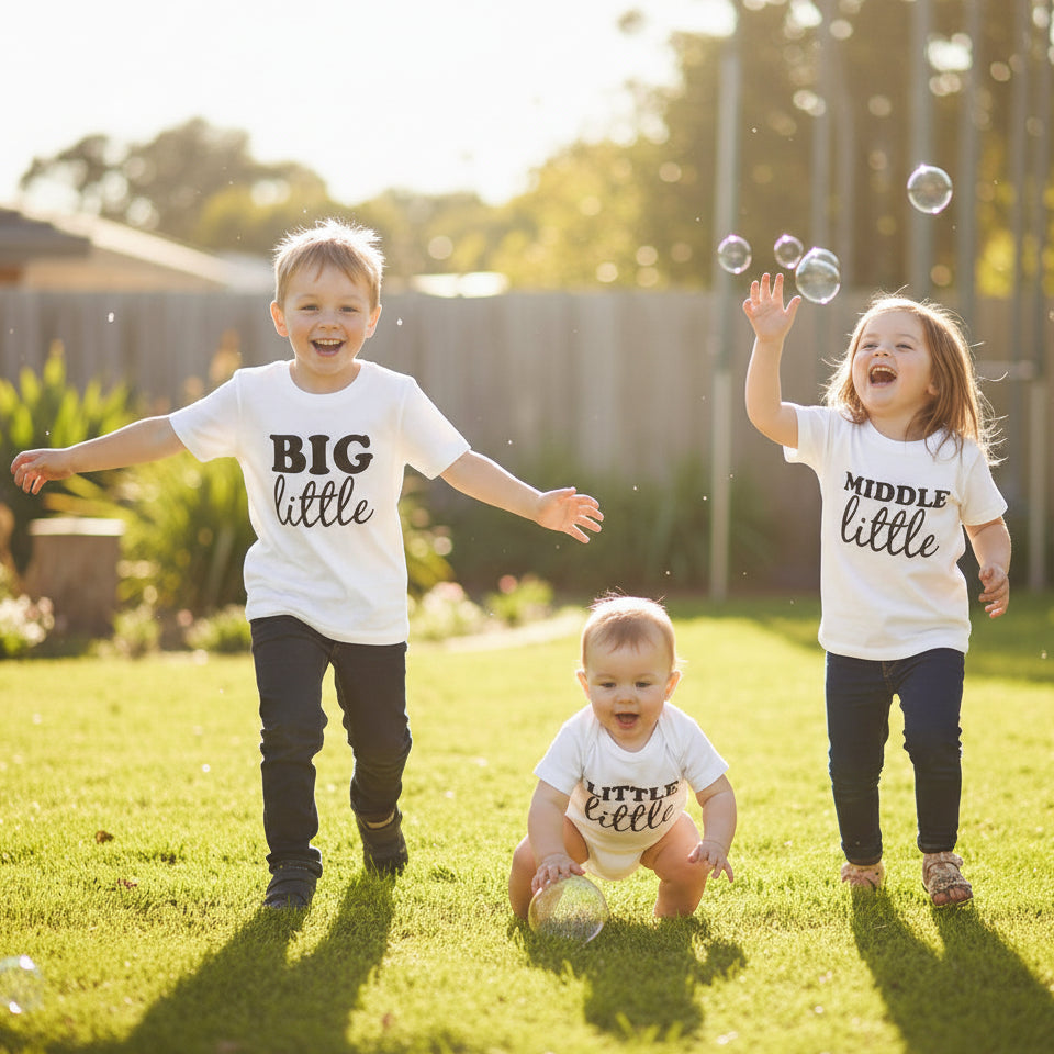 Three children wearing t-shirts with text running in a backyard.
