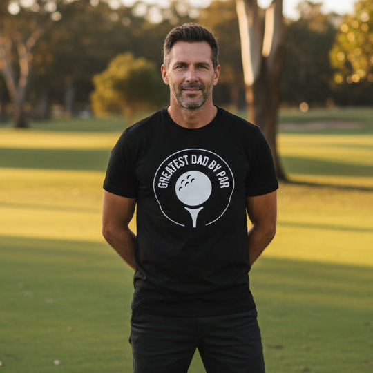 black t-shirt with a golf ball and tee emblem reading Greatest Dad By Par.