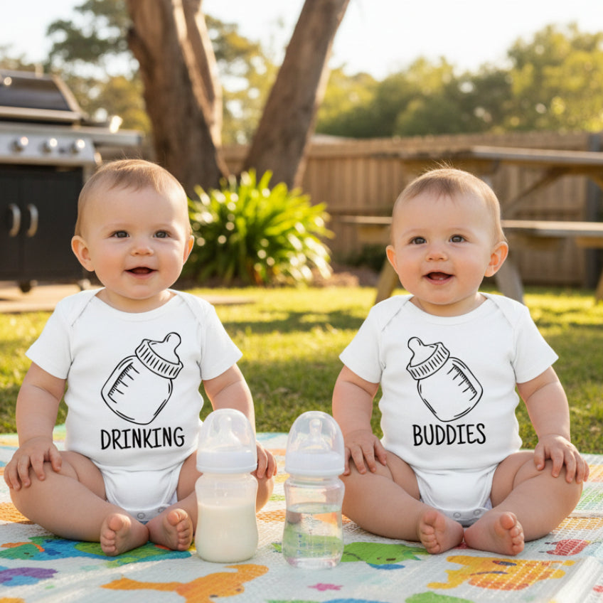 Two white baby onesies with black text and bottle illustrations on a white background.
