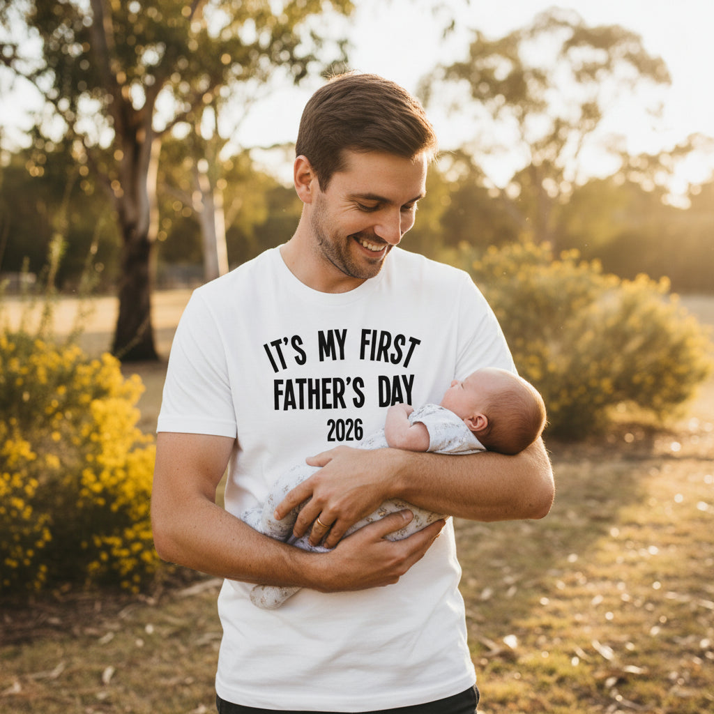 White men's tee that reads It's My First Father's Day with the year
