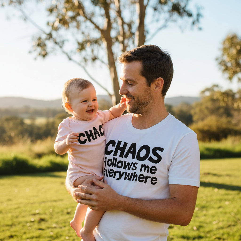 White t-shirt reading Chaos Follows Me Everywhere beside a pink baby bodysuit reading Chaos.