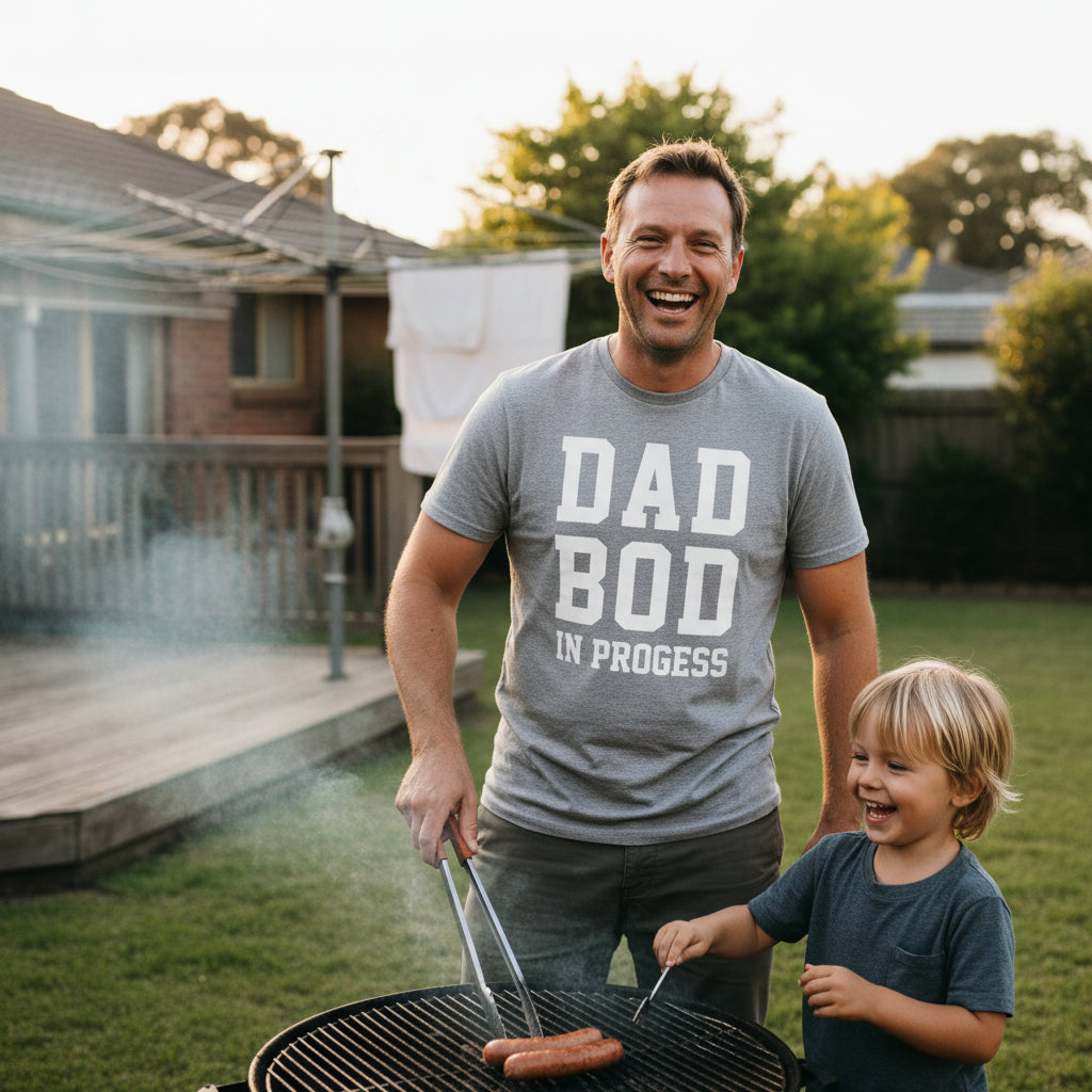 grey t-shirt reading Dad Bod In Progress in bold white varsity lettering.