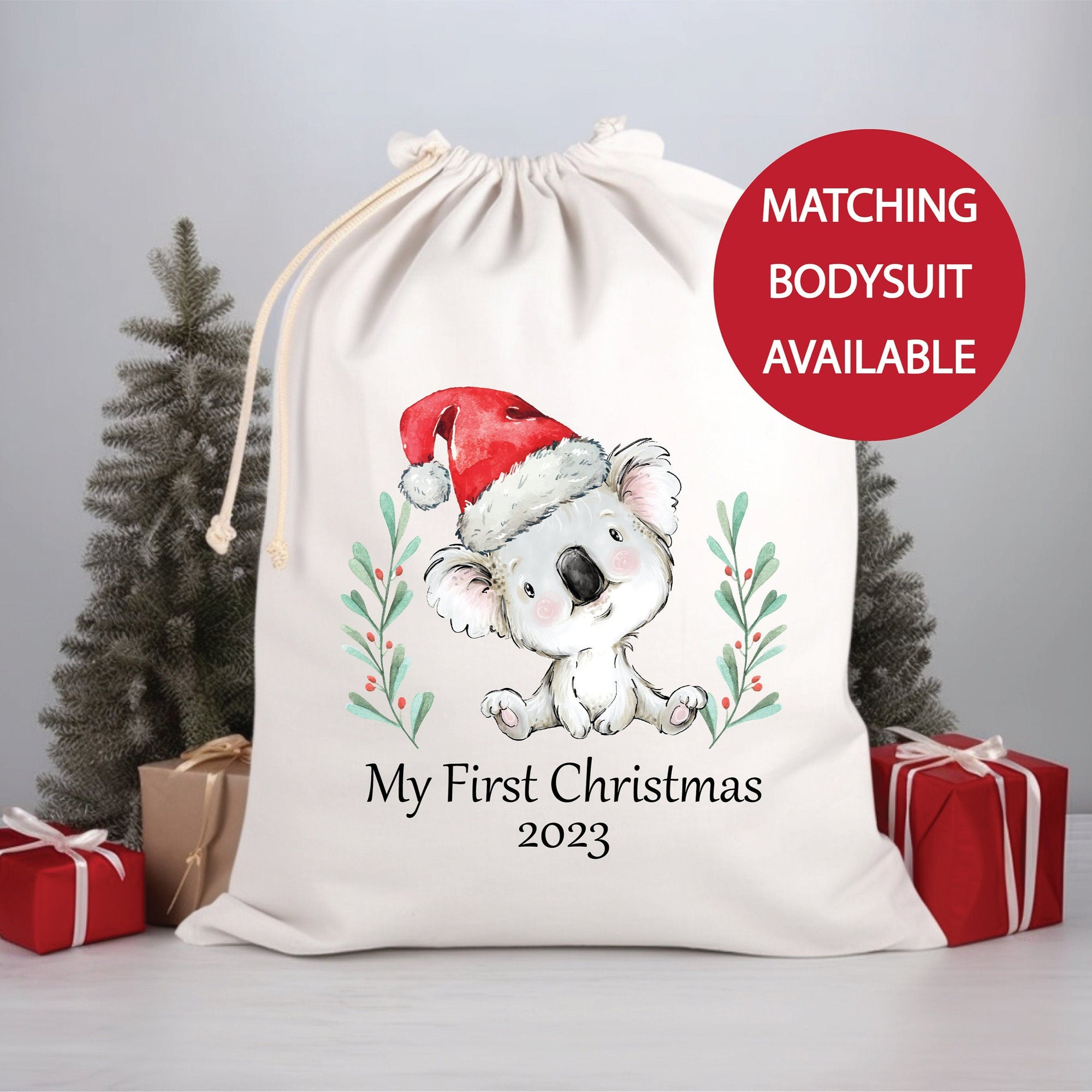 Christmas-themed gift bag with a koala design and text 'My First Christmas 2023' on a gray background.