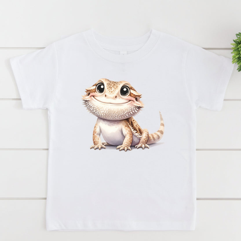 White t-shirt with a cartoon bearded dragon graphic and 'All Sizes!' text on a white background.