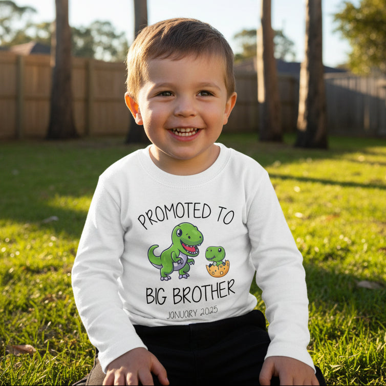 White kids t-shirt with two dinosaurs and Promoted To Big Brother slogan above a personalised date.
