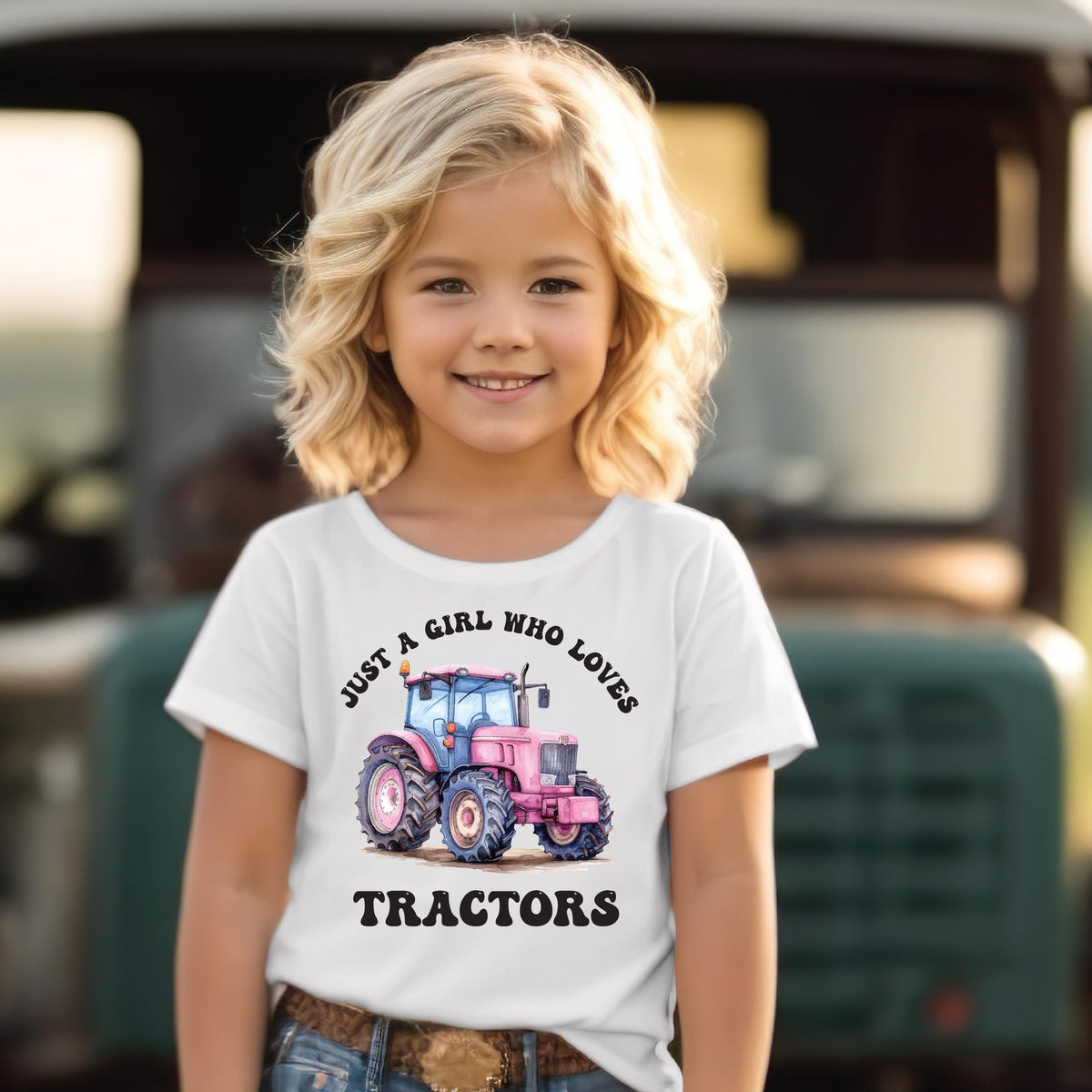Smiling young girl wearing a white Just A Girl Who Loves Tractors t-shirt with a watercolour pink tractor design