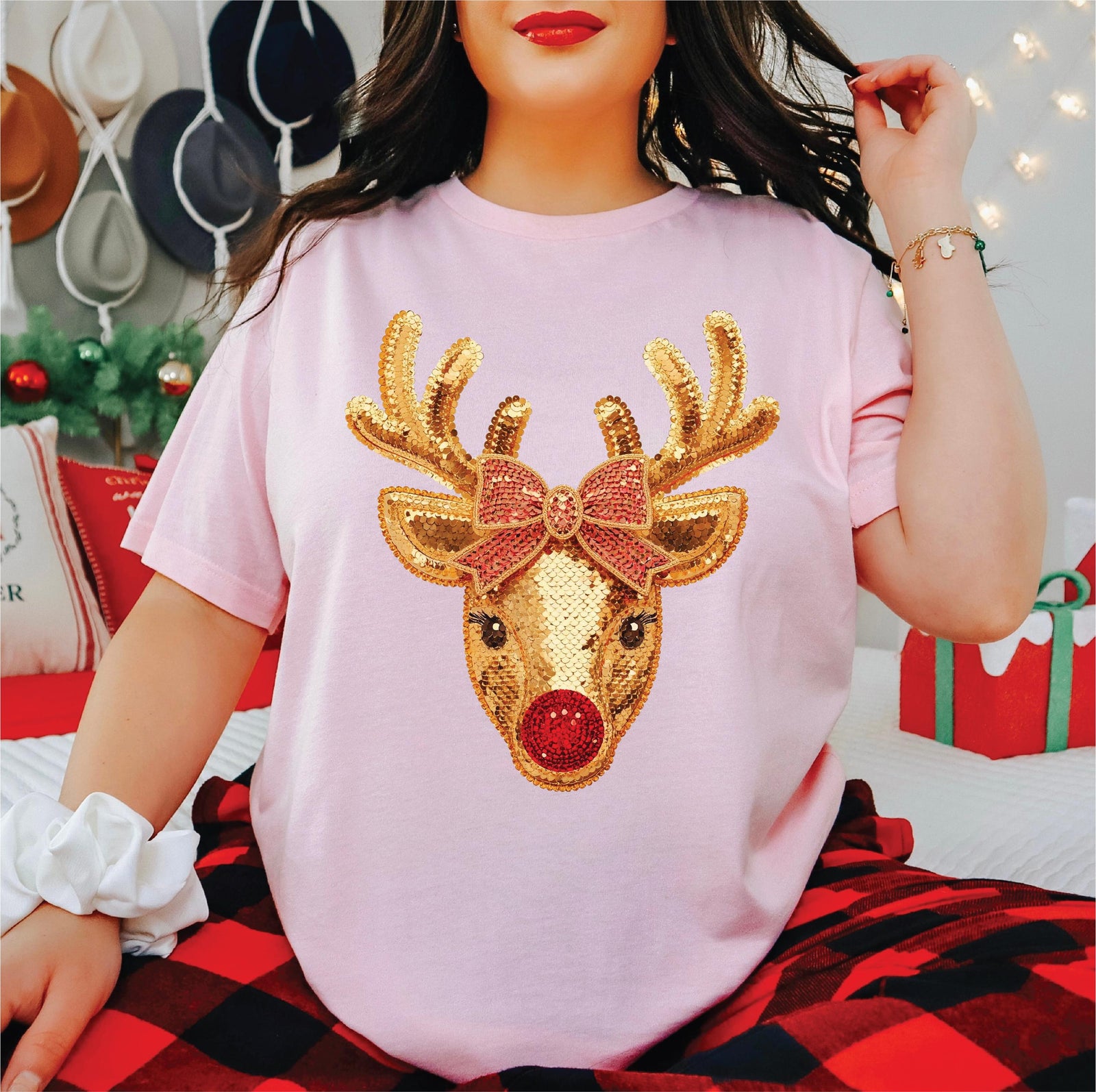 Pink t-shirt with a printed gold faux sequin reindeer with a red nose and a pink bow.