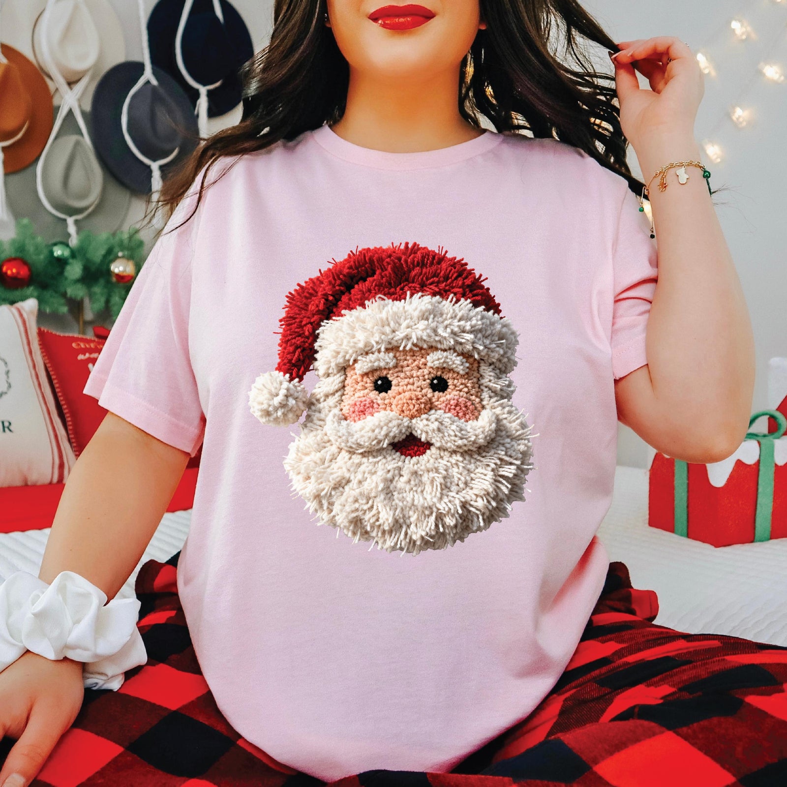 A black long-sleeve crewneck sweatshirt featuring a textured, plush 3D graphic of a Santa Claus face on the chest, complete with a red hat, white beard, and pink nose, shown against a plain white background.