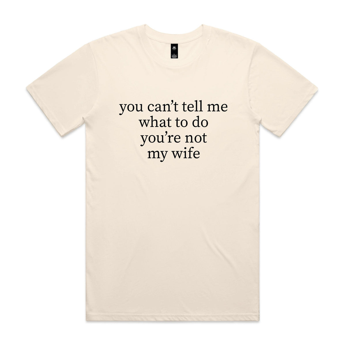 Natural cream t-shirt with black serif text reading you can't tell me what to do you're not my wife, displayed flat against a white background.