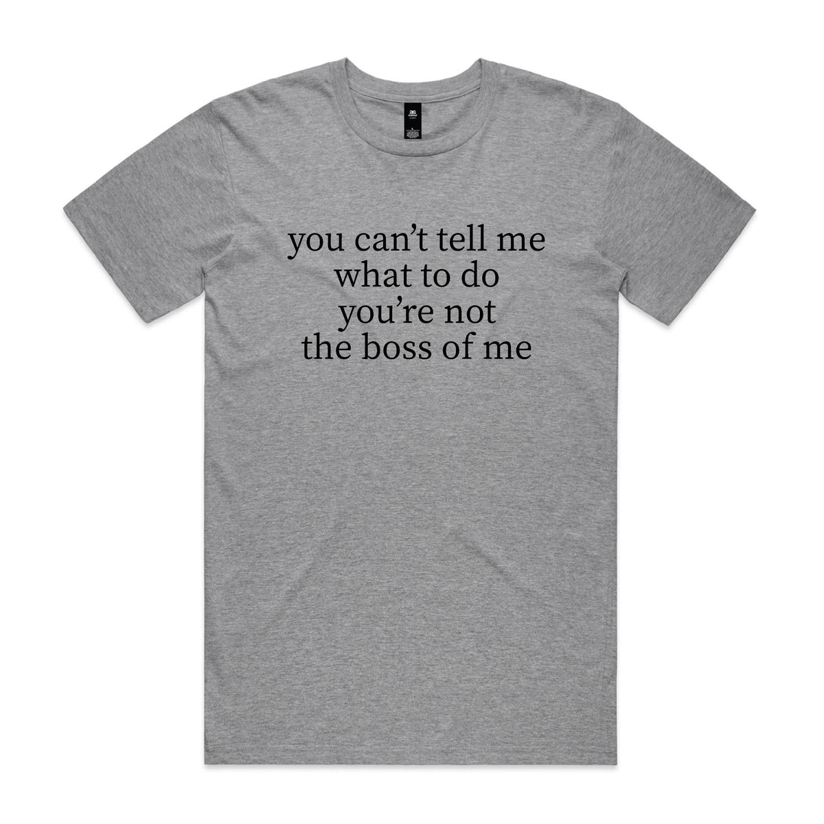 Smiling older man with crossed arms standing in a backyard, wearing a grey marle t-shirt with black serif text reading you can't tell me what to do you're not the boss of me.