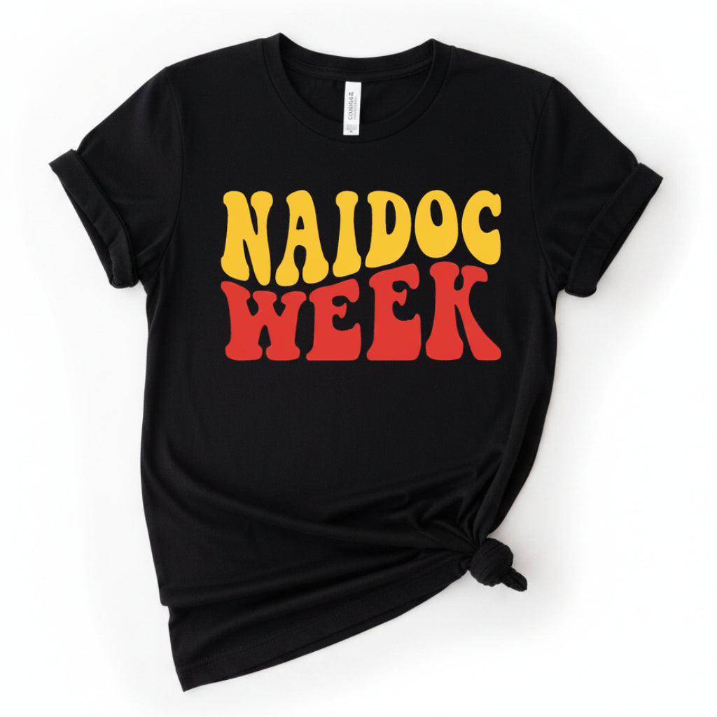 Black t-shirt with bold NAIDOC Week wavy block lettering in golden yellow and red