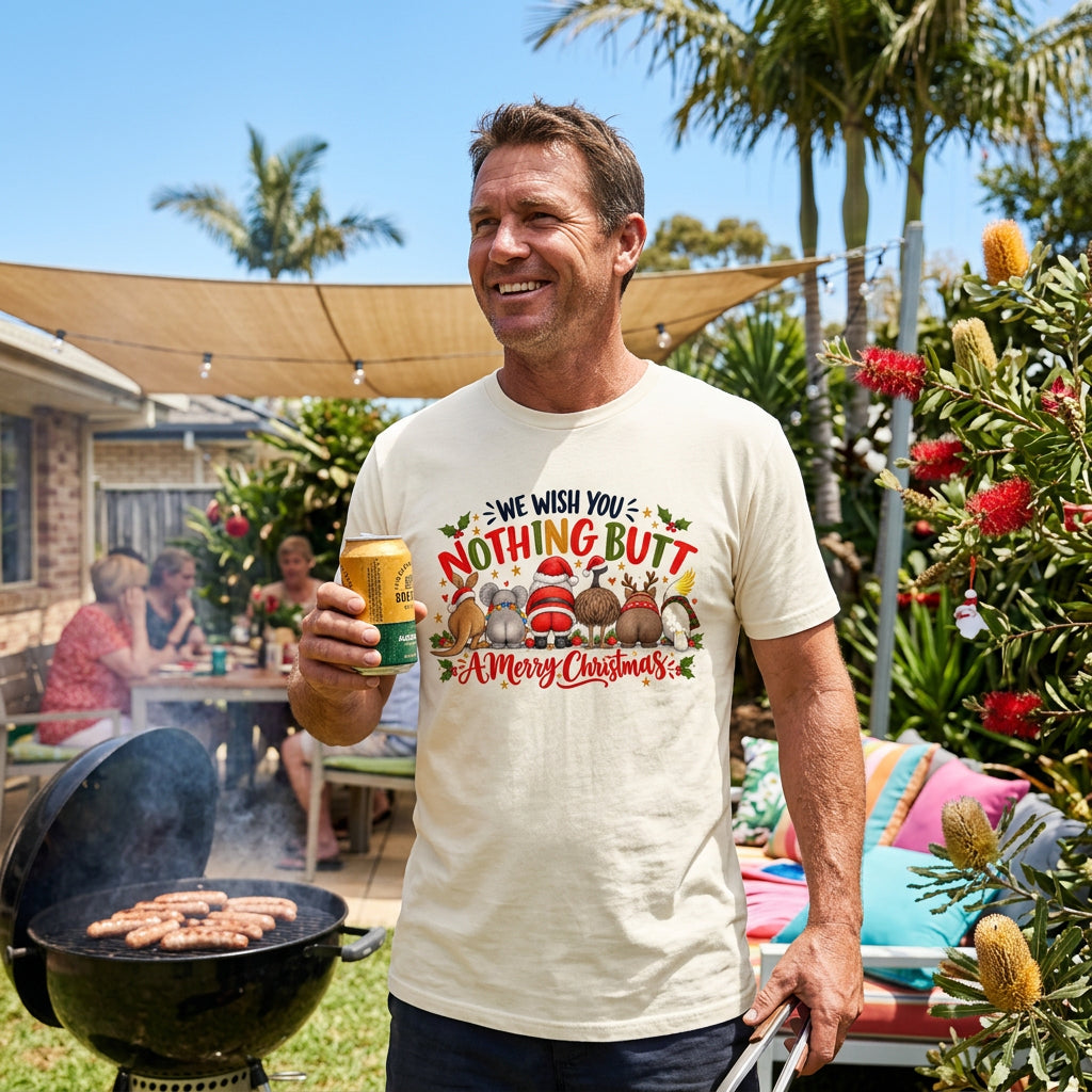 An off-white crewneck t-shirt featuring a colorful Christmas-themed graphic with the text 'WE WISH YOU NOTHING BUTT A Merry Christmas' and Australian cartoon animals in Santa hats from behind.