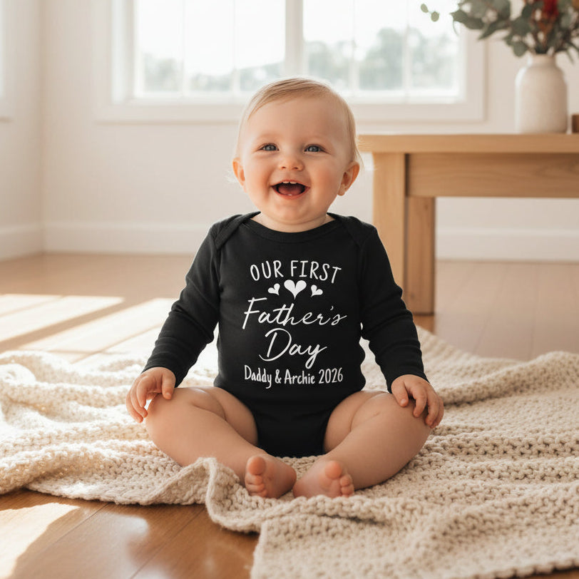 black long-sleeve baby bodysuit with Our First Father's Day and personalised names and year.