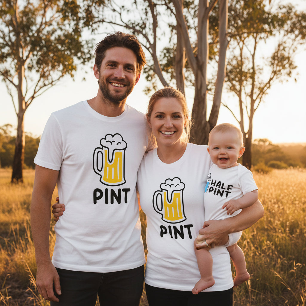 A white adult T-shirt and a white baby bodysuit displayed on a plain white background. The adult shirt has a large beer mug graphic with yellow beer and the word 'PINT' below.