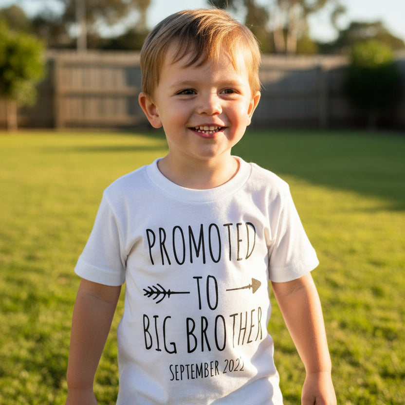 Child wearing Promoted To Big Brother pregnancy announcement shirt outdoors
