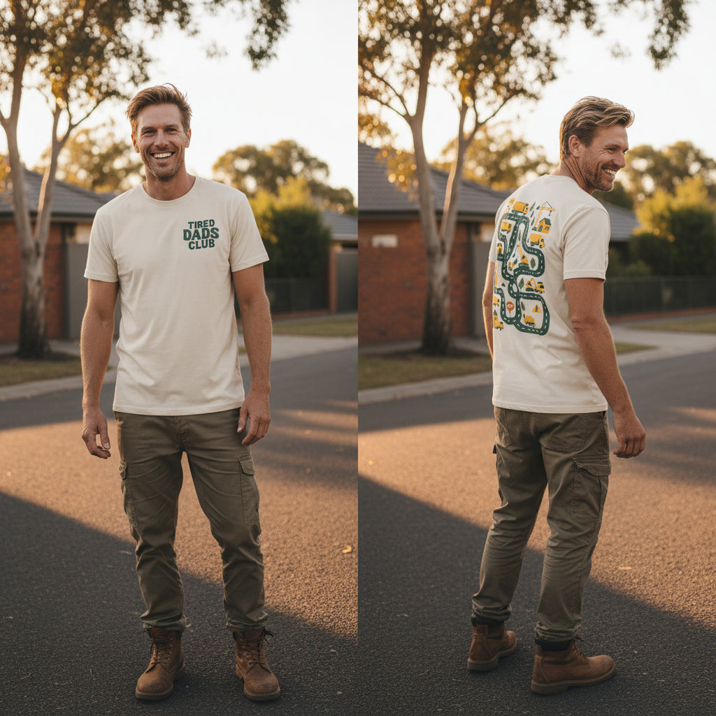 A light beige crewneck t-shirt shown from both front and back. The front features the text 'TIRED DADS CLUB' in dark green.