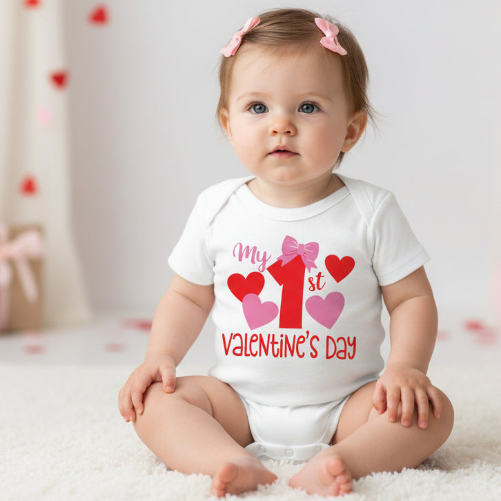 A white bodysuit for babies with the text 'MY 1ST VALENTINE'S DAY'S and heart illustrations.